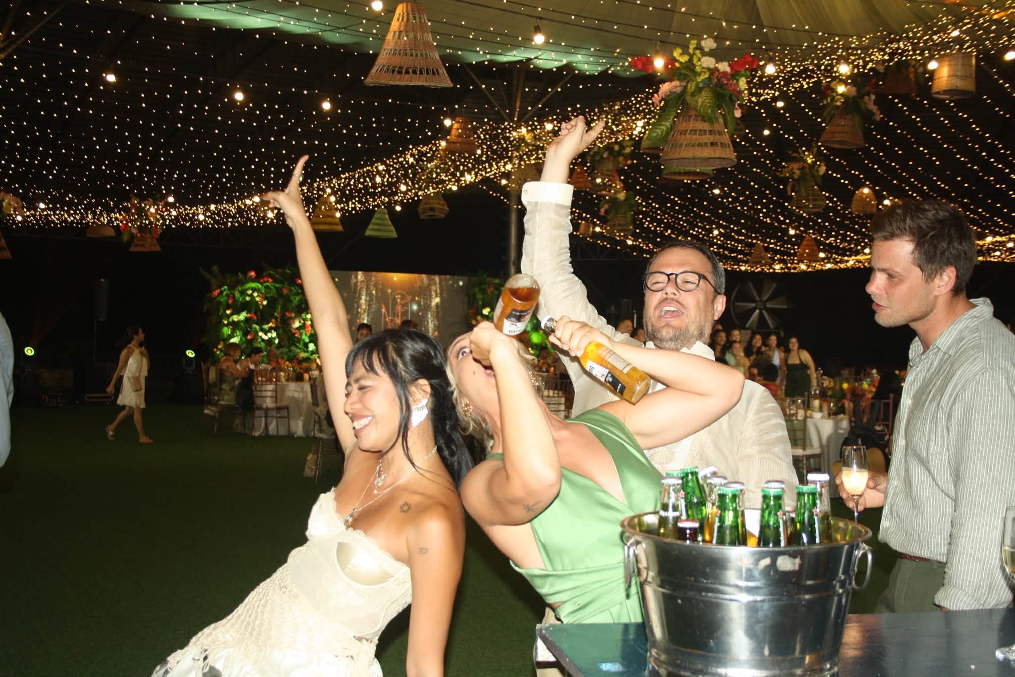 Wedding guests celebrating beside a bucket of drinks