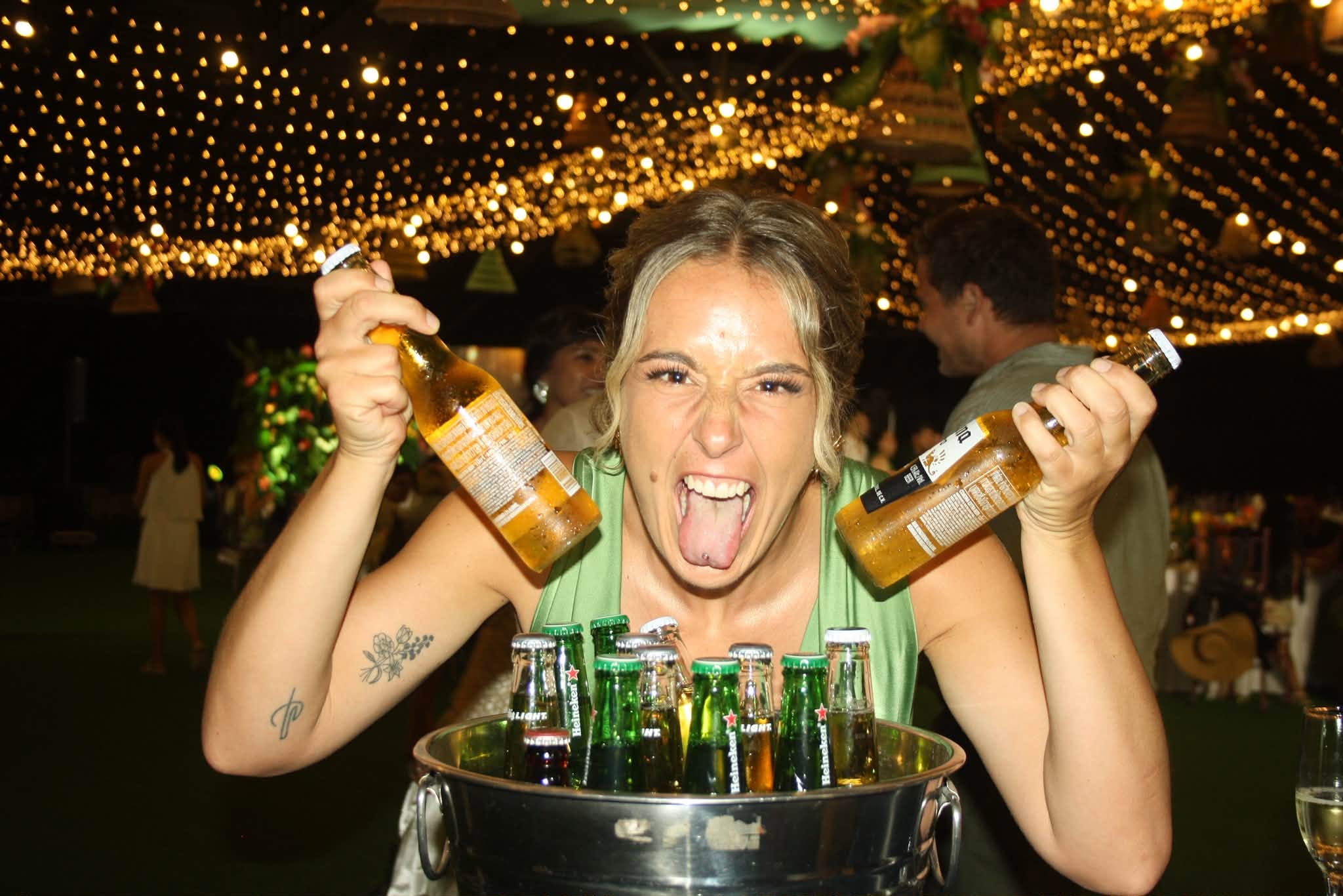 A guest smiling with two bottles at the mobile bar