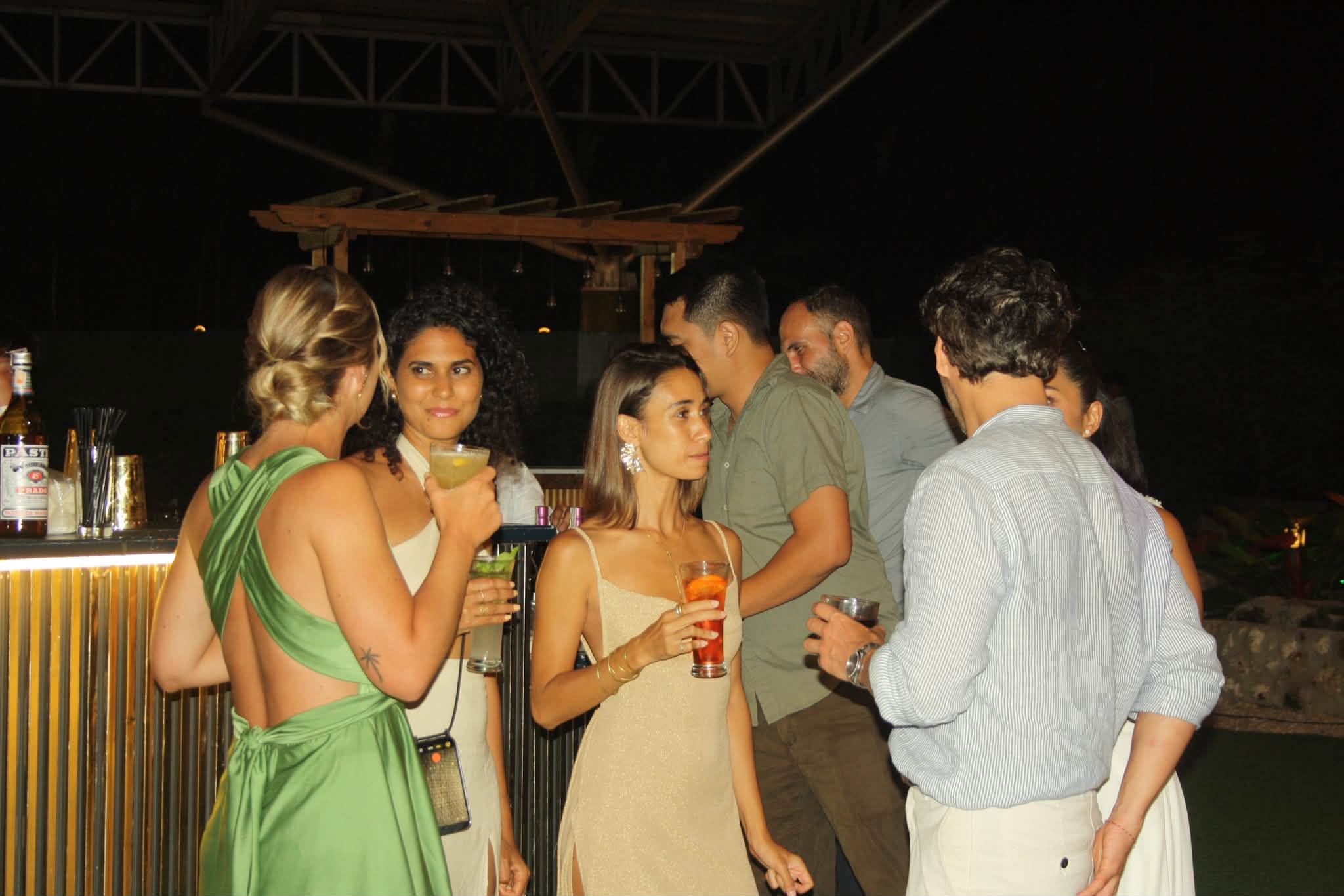 Guests holding colorful cocktails beside the mobile bar